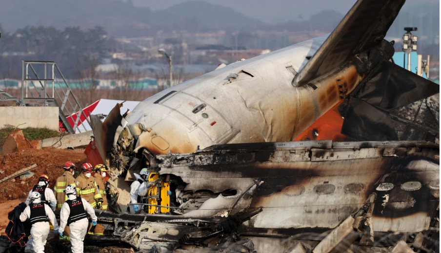 Bomberos trabajan cerca de los restos del avión accidentado en Corea del Sur. (Foto Prensa Libre: EFE)