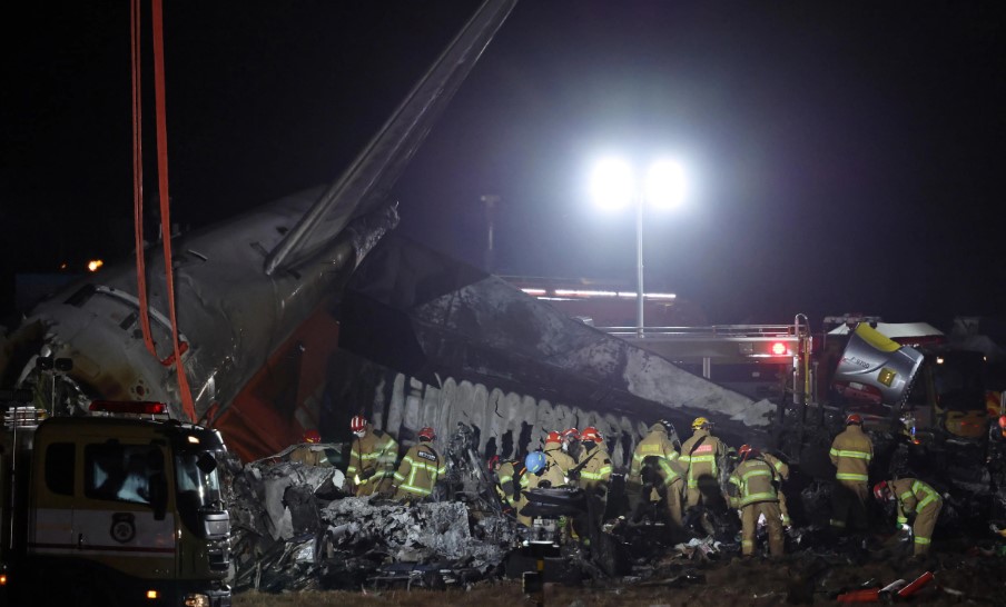 Bomberos trabajan en los restos de un avión en Corea del Sur. (Foto Prensa Libre: EFE)