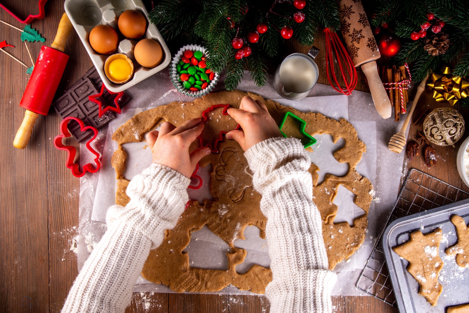 Cocinar las galletas de Navidad de fondo familiar. Las manos de la madre y la hija se ven en el fondo de madera acogedor, haciendo galletas de jengibre con cortadores de galletas, con decoración de Navidad de Año Nuevo