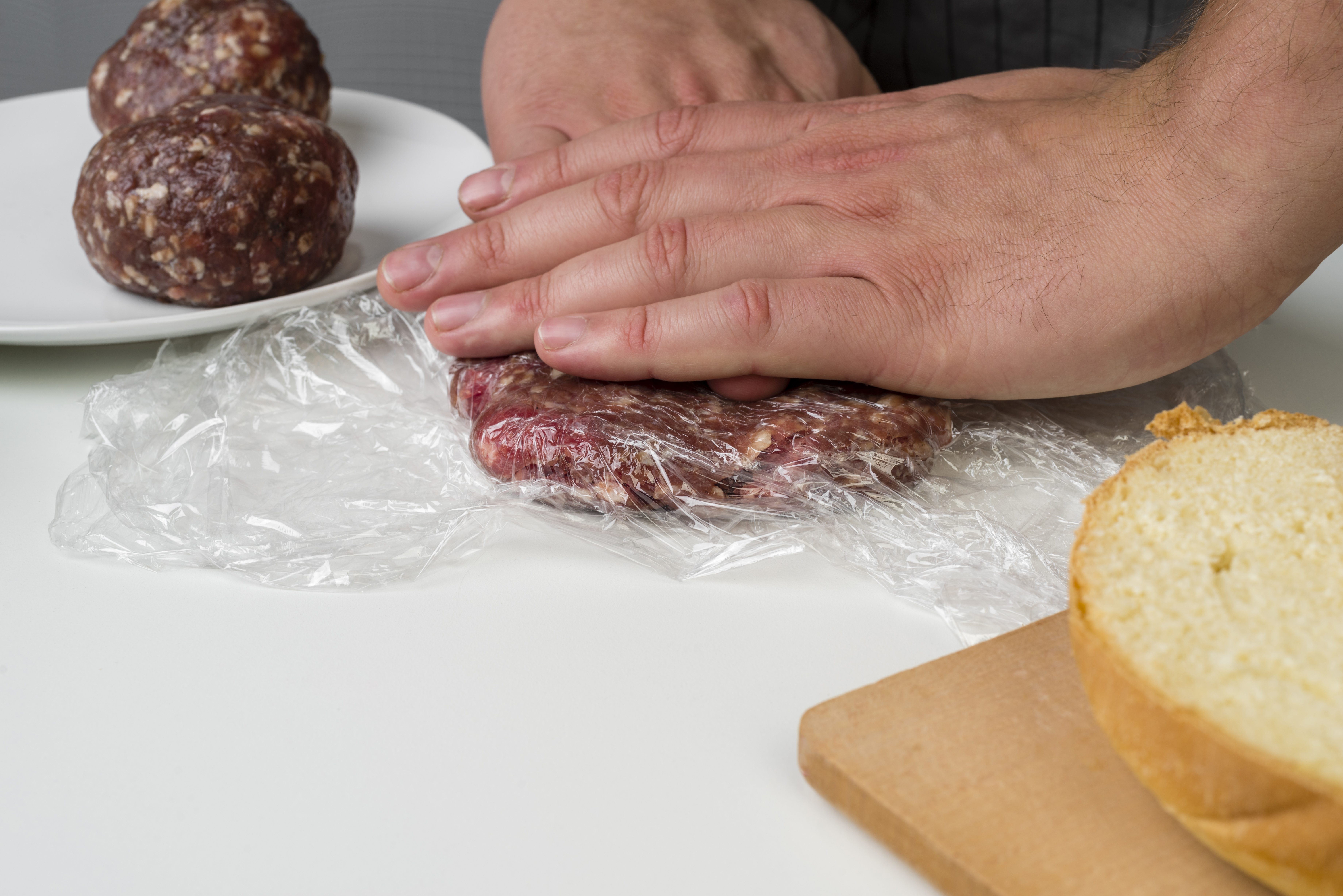 una persona preparando carne para hamburguesa