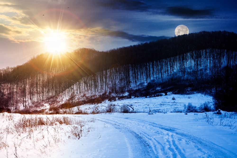 paisaje con bosque sin hojas sobre una colina cubierta de nieve bajo un cielo con sol y luna. concepto de cambio de día y noche en el solsticio de invierno