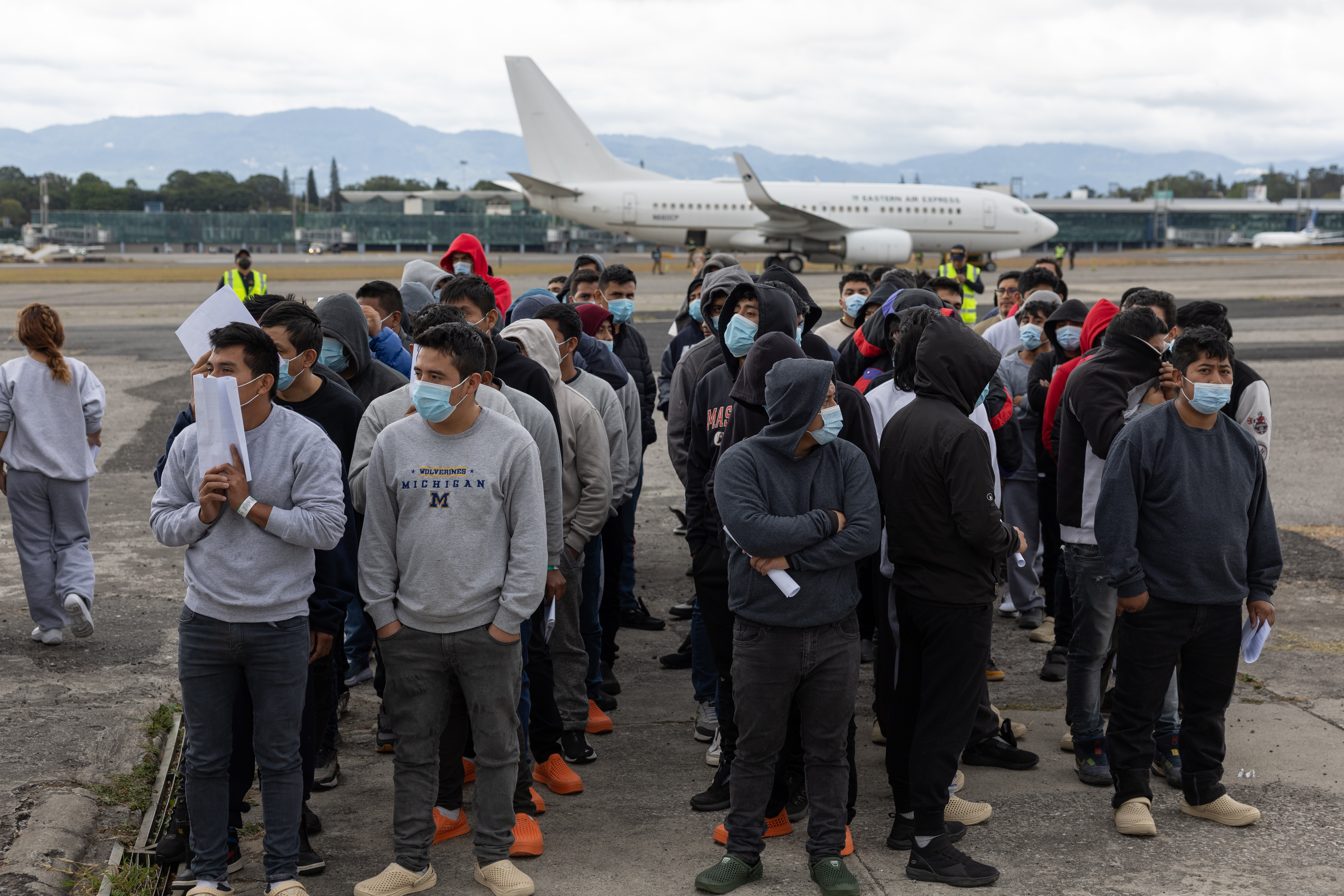 AME1964. CIUDAD DE GUATEMALA (GUATEMALA), 17/01/2025.- Fotografía del 2 de enero de 2025 de un grupo de guatemaltecos esperando en la base de la Fuerza Aérea de Guatemala, durante el primer vuelo de deportados enviado por Estados Unidos desde El Paso, Texas, en Ciudad de Guatemala (Guatemala). Desde la instalación de albergues temporales para retornados hasta amenazas de expulsar una base militar de EE.UU. Así afronta Centroamérica la promesa de deportaciones masivas del nuevo Gobierno estadounidense de Donald Trump, que tendría un fuerte impacto en esta región emisora histórica de migrantes y que depende, en gran medida, de las remesas de su diáspora en la nación norteamericana. EFE/ David Toro