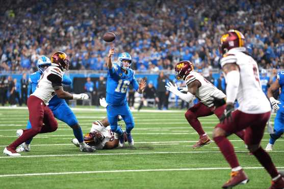 DETROIT, MICHIGAN - JANUARY 18: Jared Goff #16 of the Detroit Lions throws a pass for a touchdown as he is hit during the second quarter Washington Commanders in the NFC Divisional Playoff at Ford Field on January 18, 2025 in Detroit, Michigan.   Nic Antaya/Getty Images/AFP (Photo by Nic Antaya / GETTY IMAGES NORTH AMERICA / Getty Images via AFP)