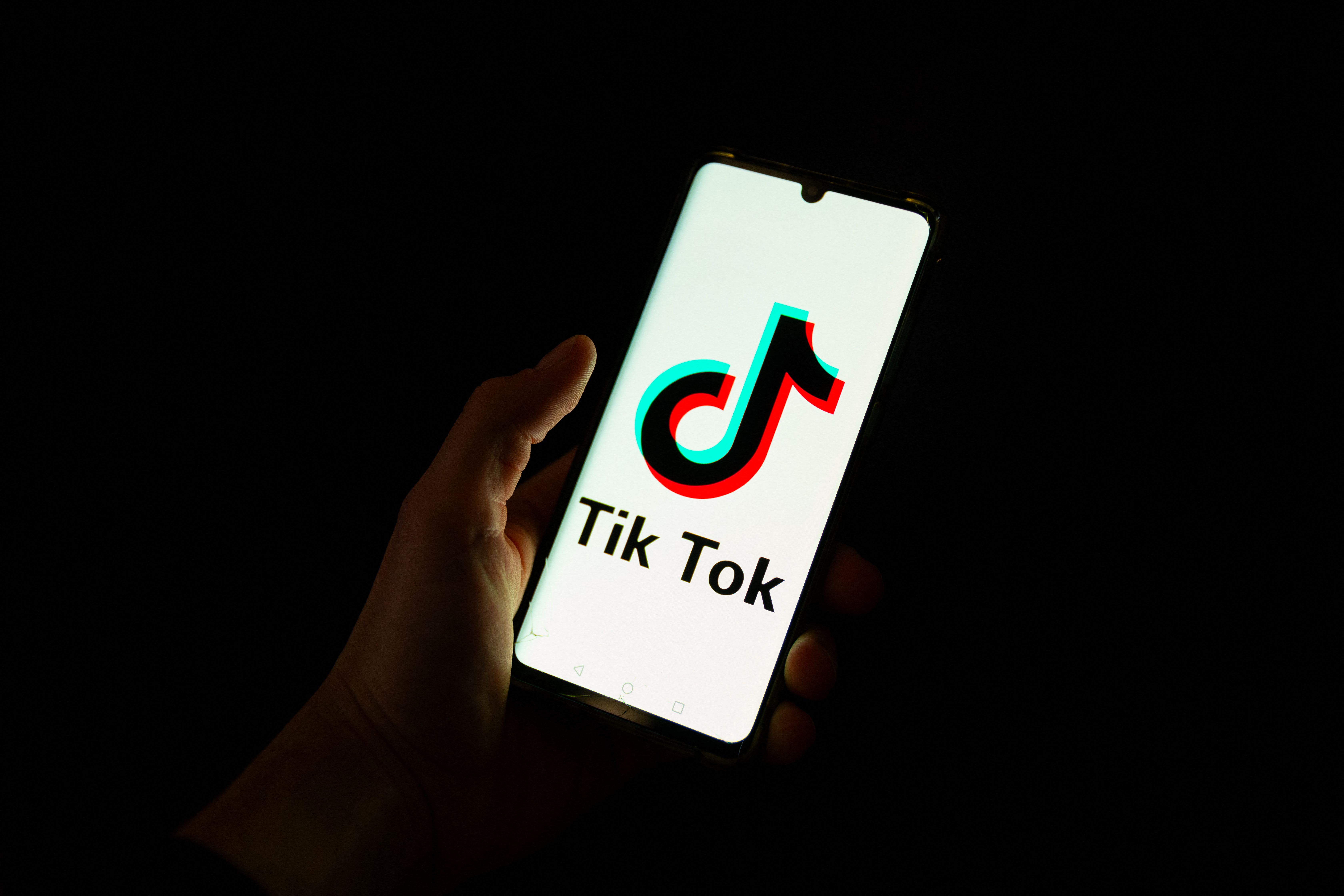 (FILES) This photograph taken on April 19, 2024 shows a man holding a smartphone displaying the logo of Chinese social media platform Tiktok in an office in Paris. The US Supreme Court on January 17, 2025, upheld a law that will ban TikTok in the United States, potentially denying the video-sharing app to 170 million users in the United States starting on January 19. (Photo by Antonin UTZ / AFP)