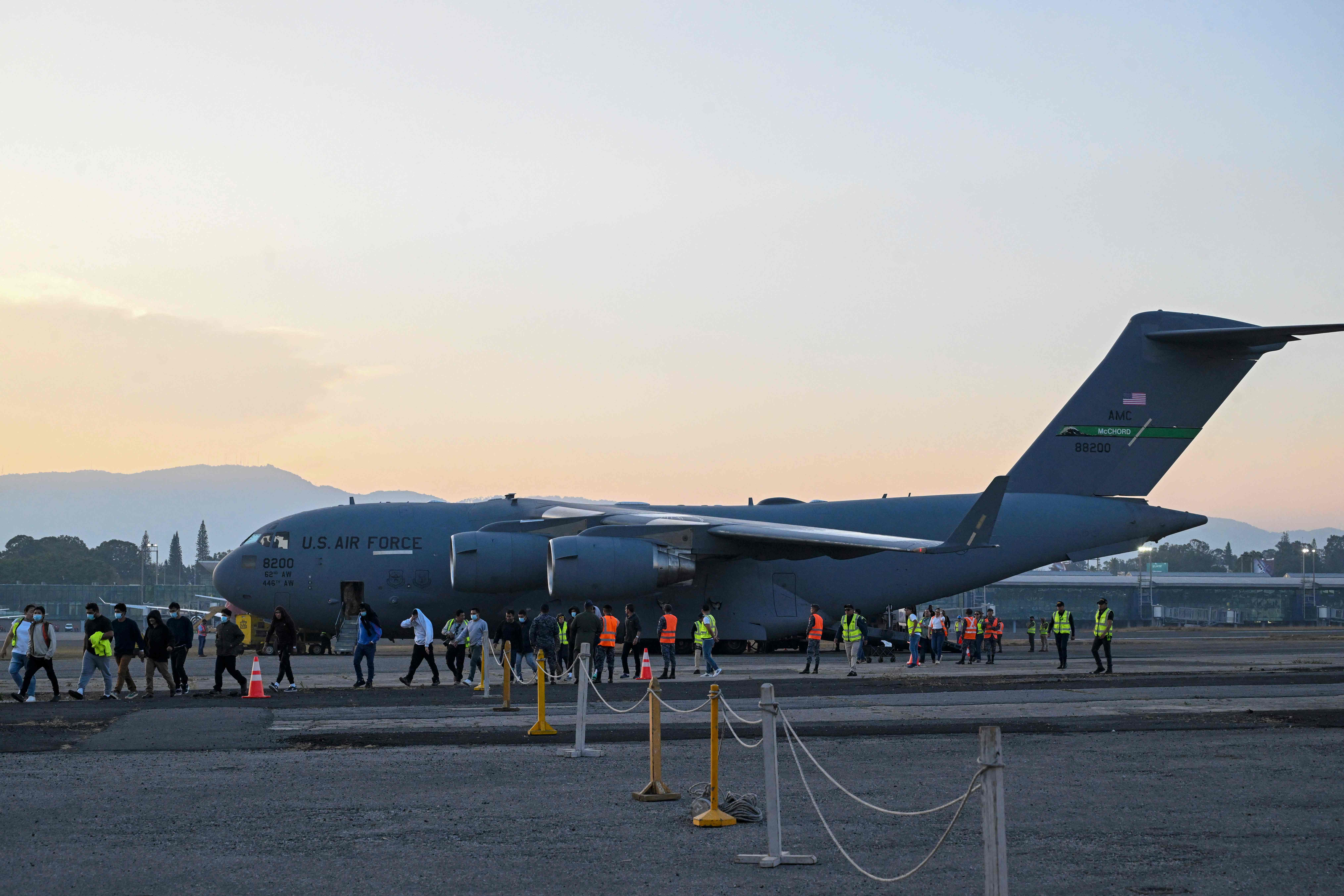 Guatemalan migrants deported from the United States on a U.S. military plane walk down the runway at the Guatemalan Air Force Base in Guatemala City on January 30, 2025. (Photo by JOHAN ORDONEZ / AFP)