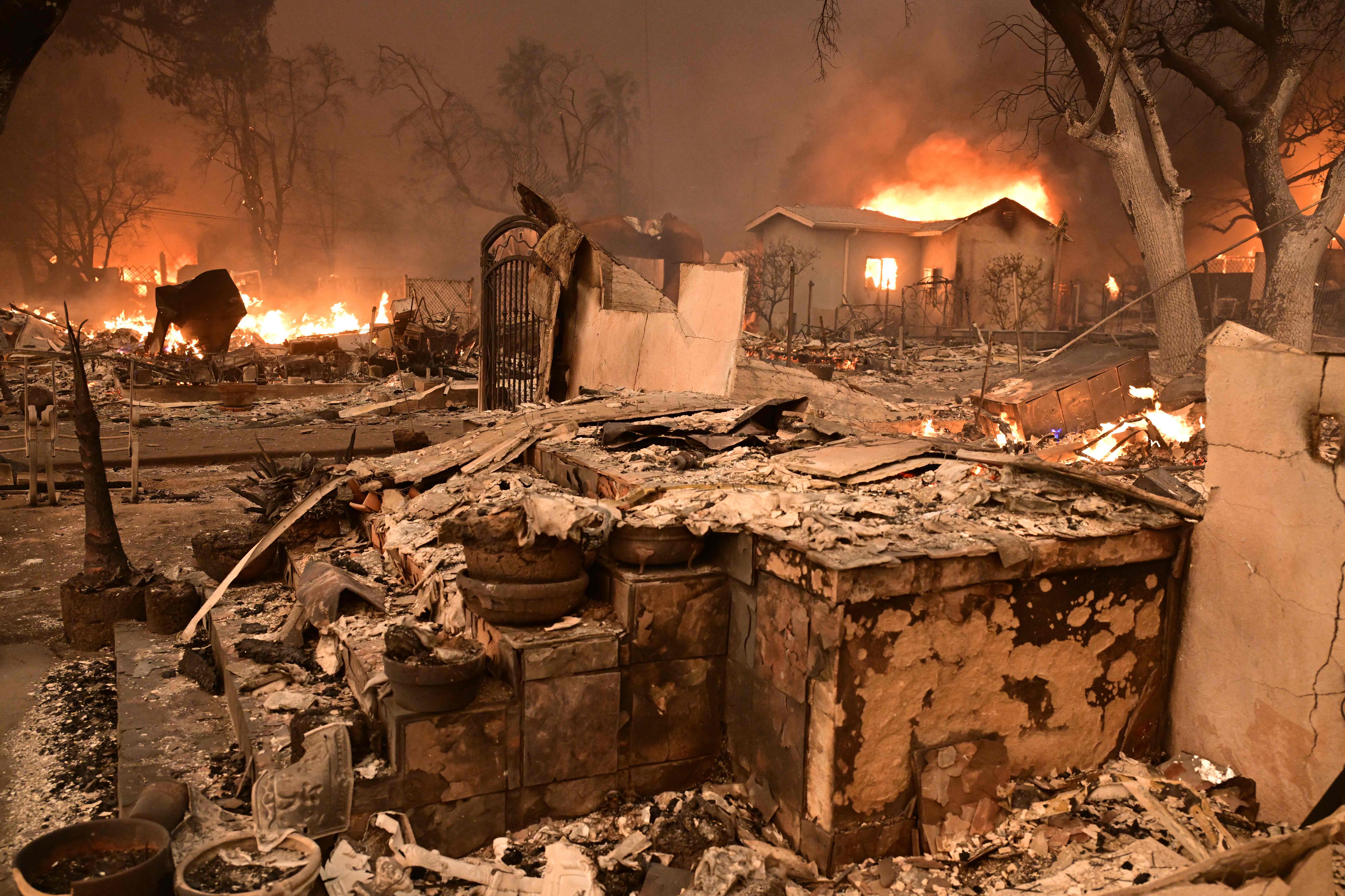 Homes burn during the Eaton Fire in Altadena, California' on January 8, 2025. Rampaging wildfires around Los Angeles have killed at least two people, officials said January 8 as terrifying blazes leveled whole streets, torching cars and houses in minutes.
More than 1,000 buildings have burned in multiple wildfires that have erupted around America's second biggest city, forcing tens of thousands of people from their homes. (Photo by Robyn Beck / AFP)