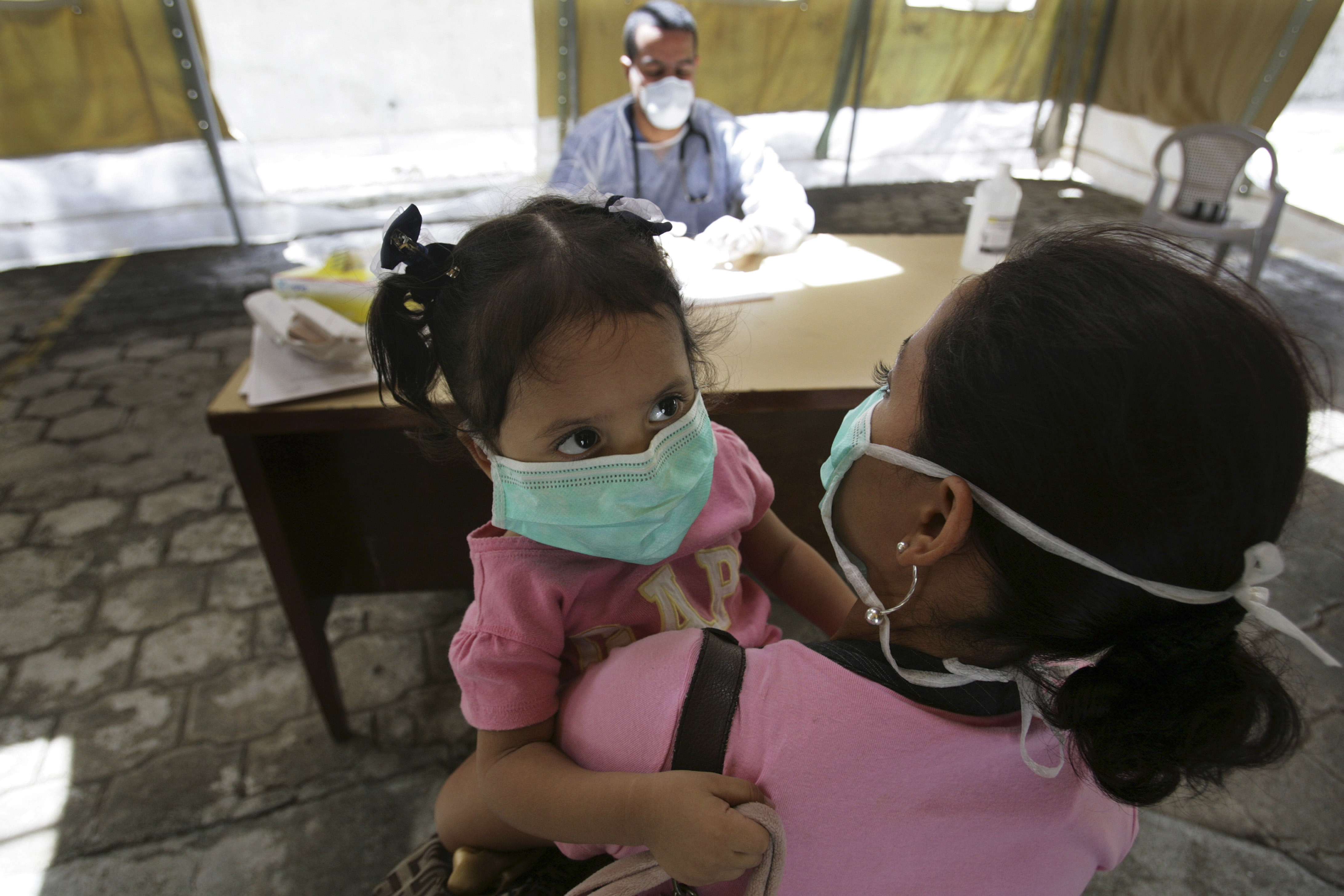 A doctor talks to a mother before testing her child for the influenza A (H1N1) virus at a mobile clinic in the Children's Hospital in Managua June 2, 2009.  Nicaragua's health authorities on Tuesday announced that the first case of H1N1 flu has been reported in Nicaragua.     REUTERS/Oswaldo Rivas (NICARAGUA HEALTH)