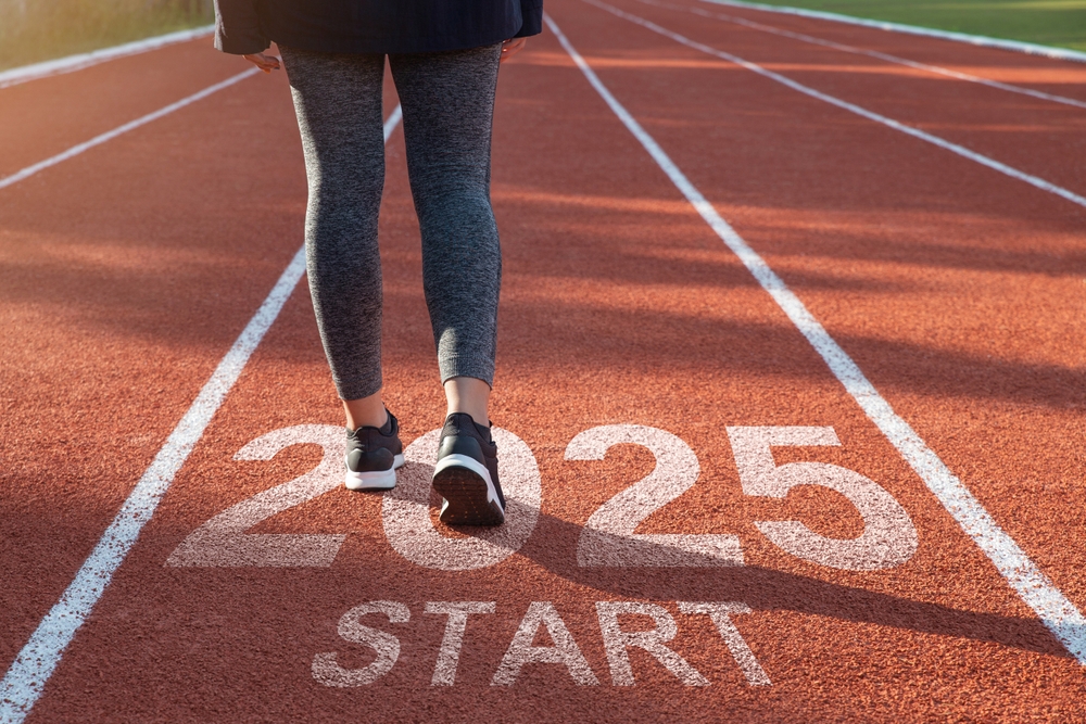 Comenzando el nuevo año 2025. mujer preparándose para comenzar en una pista de atletismo grabada con el año 2025. idea para la planificación, los objetivos y las resoluciones del año Nuevo. Adoptar el éxito en 2025 para la vida Nueva.