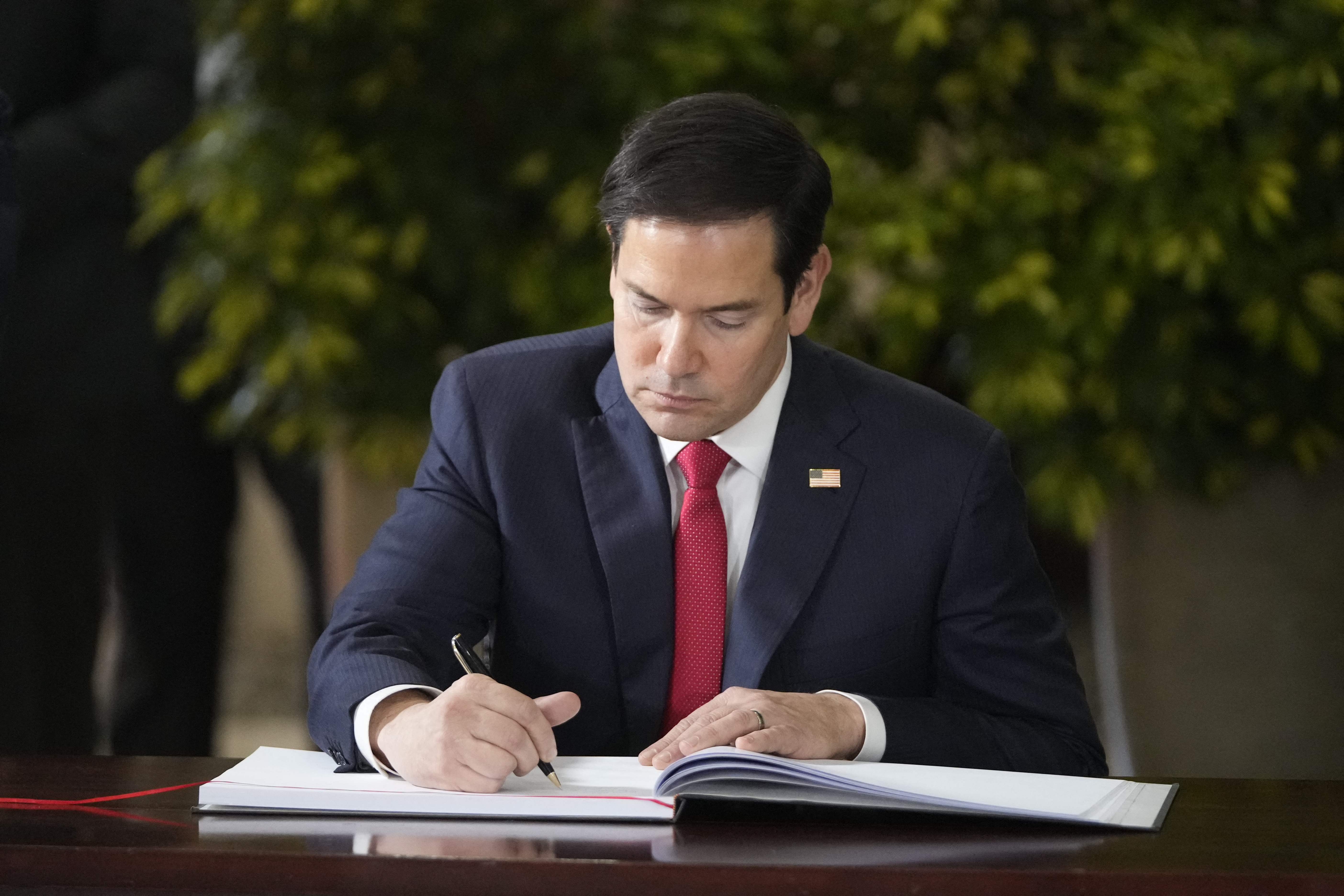 US Secretary of State Marco Rubio signs the guest book at the presidential palace in San Jose, Costa Rica on February 4, 2025. (Photo by Mark Schiefelbein / Pool AP / AFP)