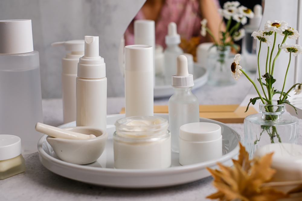 The collection of white skincare products in a tray for beauty and self-care routines.